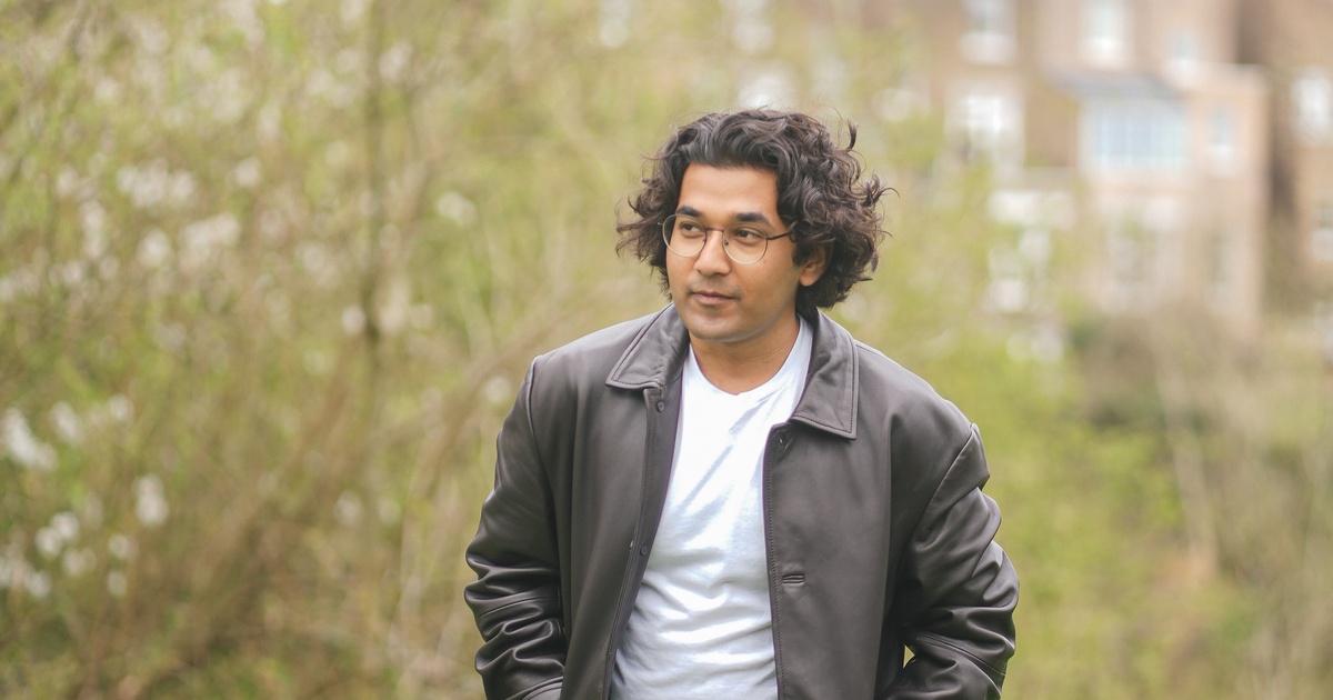 Aryan standing in a park wearing a leather jacket