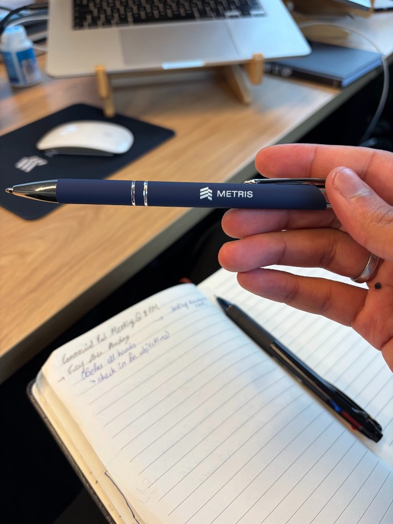 Metris pen and notebook on a desk