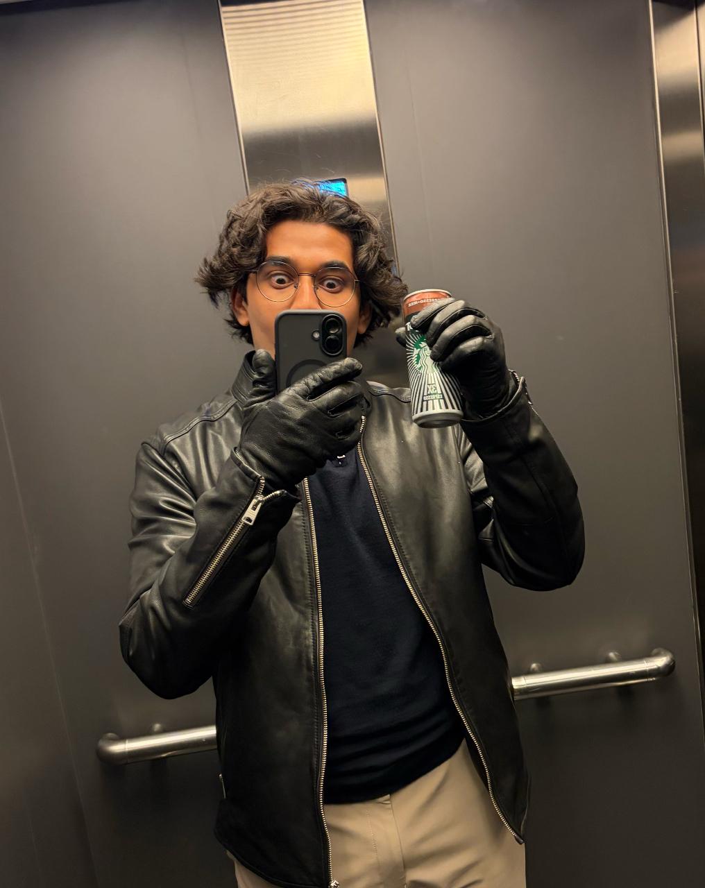Aryan with coffee in an elevator